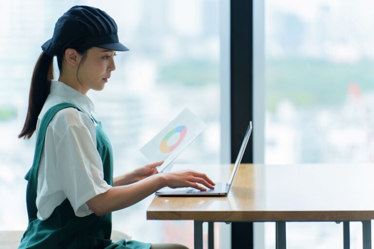 パソコンで事務仕事をする飲食店スタッフ